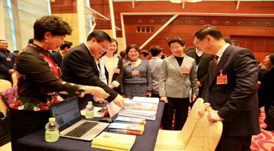 圖為市統(tǒng)計局工作人員為人大代表、政協(xié)委員做現(xiàn)場咨詢服務(wù)