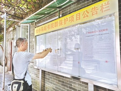 街坊通過公告欄詳細(xì)了解征收補償方案。