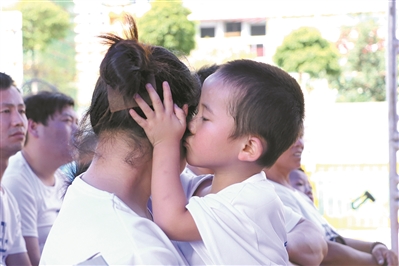 在廣州的一個“關愛留守兒童”主題的活動現(xiàn)場，孩子深情地親吻母親。（資料圖片）
