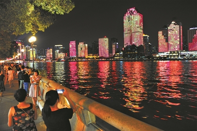 在濱江路散步的市民紛紛拿起手機(jī)拍攝對(duì)岸的美景。