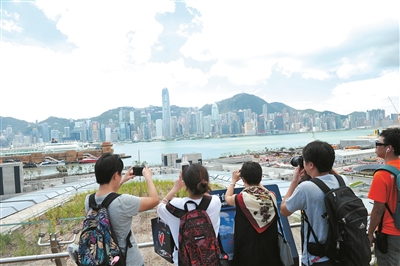 23日上午，首趟從廣州南站開(kāi)往香港西九龍站的列車(chē)7時(shí)41分抵達(dá)。圖為抵達(dá)西九龍站的旅客在拍照。