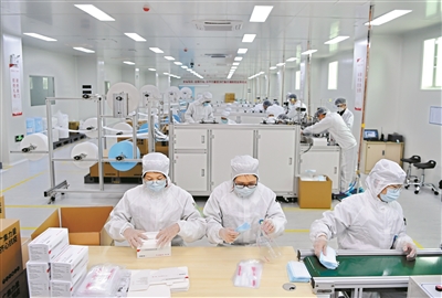 工人在流水線上，將生產(chǎn)好的口罩打包