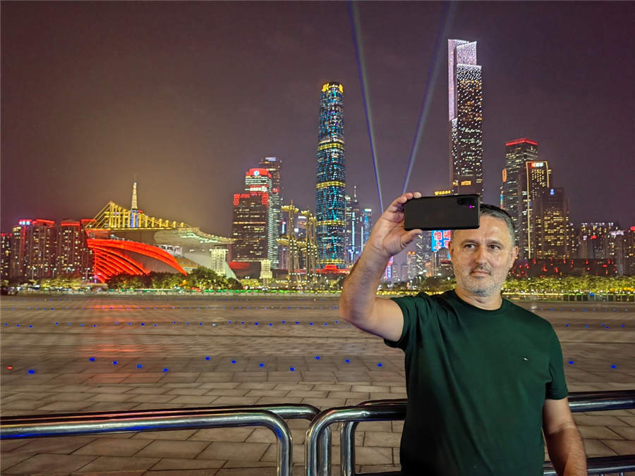 圖為外國記者用手機(jī)自拍的方式記錄美麗夜景。人民日?qǐng)?bào)記者 王影迪攝